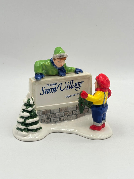 Dept 56 Original Snow Village Kids Decorating The Village Sign