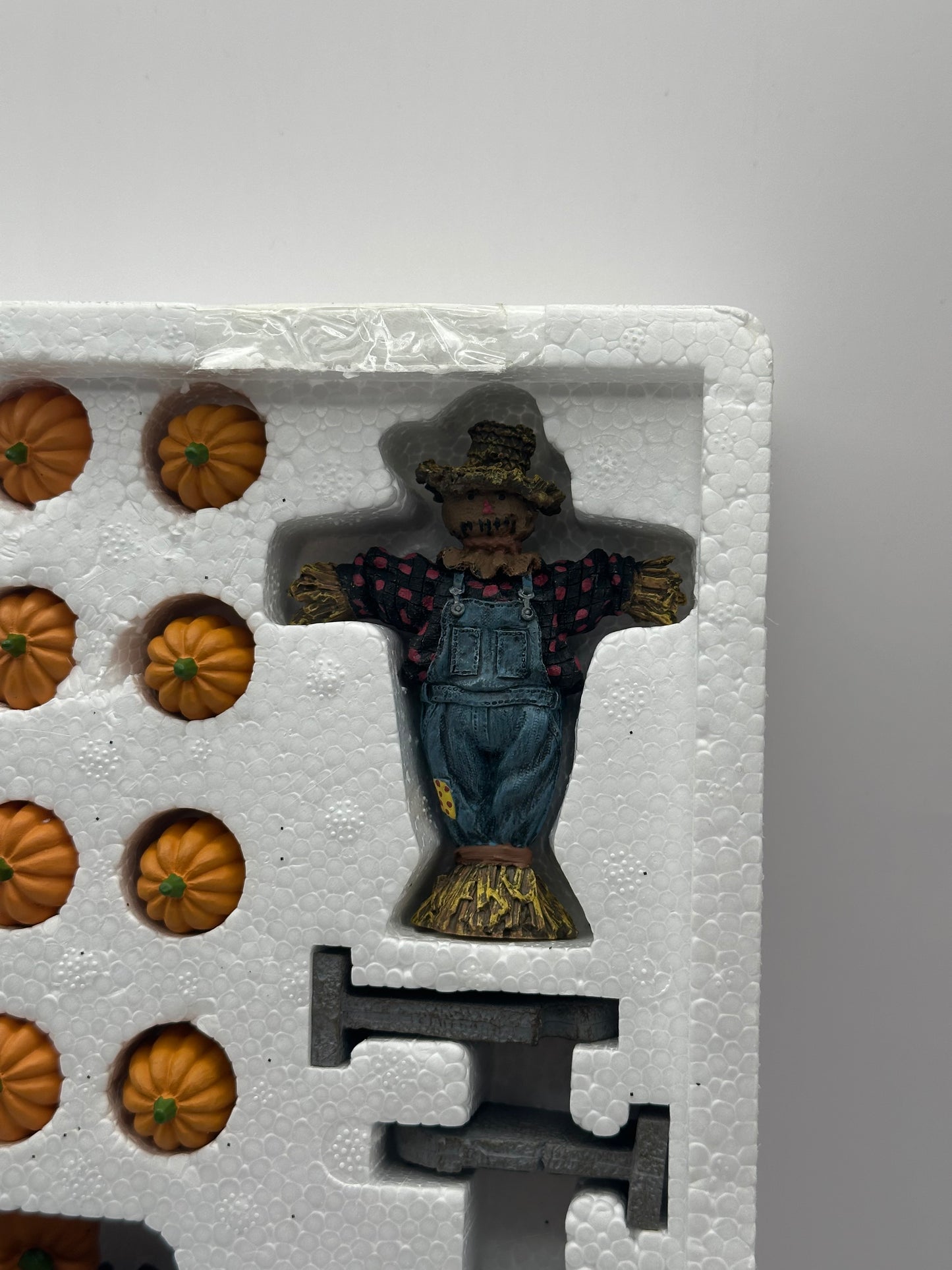 Original packaging of the Department 56 Snow Village Halloween set with contents showing the scarecrow close-up.